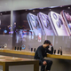 A Chinese employee with a protective mask sits in an Apple store in Beijing, China. Apple announced that it was closing its stores, offices and contact centers in the region following the coronavirus outbreak.